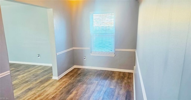 unfurnished room with baseboards and wood finished floors