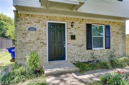 property entrance featuring brick siding