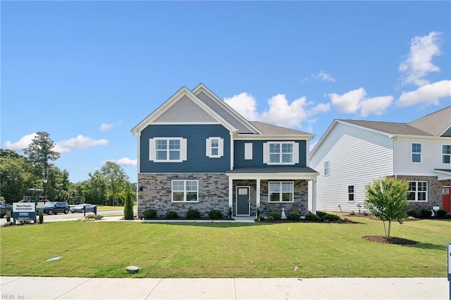 craftsman-style house with stone siding and a front yard