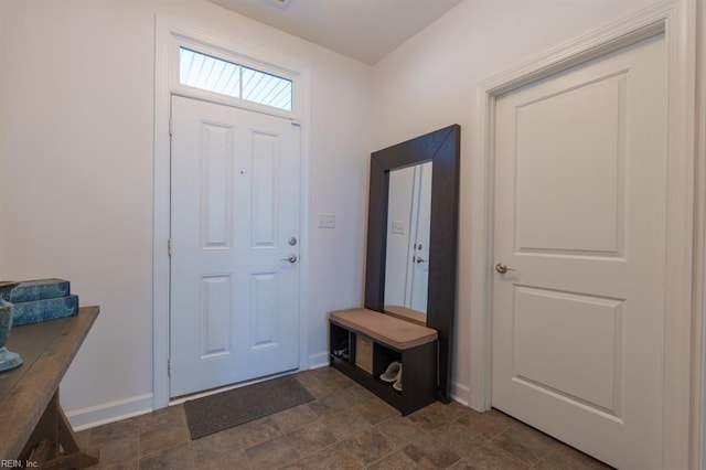 entrance foyer with baseboards and stone finish floor