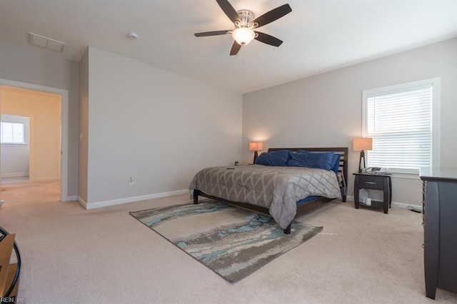 bedroom featuring visible vents, light colored carpet, and baseboards