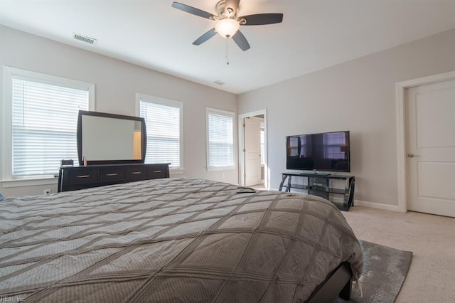 carpeted bedroom with visible vents, baseboards, and ceiling fan