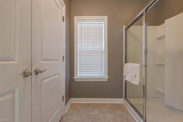 bathroom with a shower with door, tile patterned flooring, and baseboards