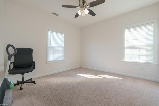 carpeted office space with plenty of natural light, visible vents, baseboards, and ceiling fan