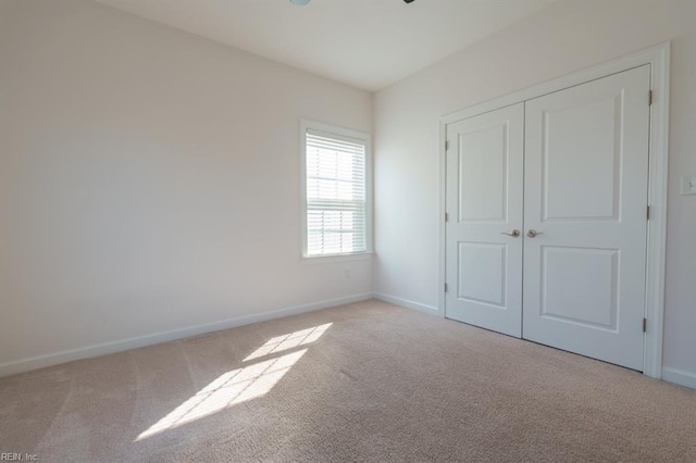 unfurnished bedroom featuring a closet, baseboards, and carpet