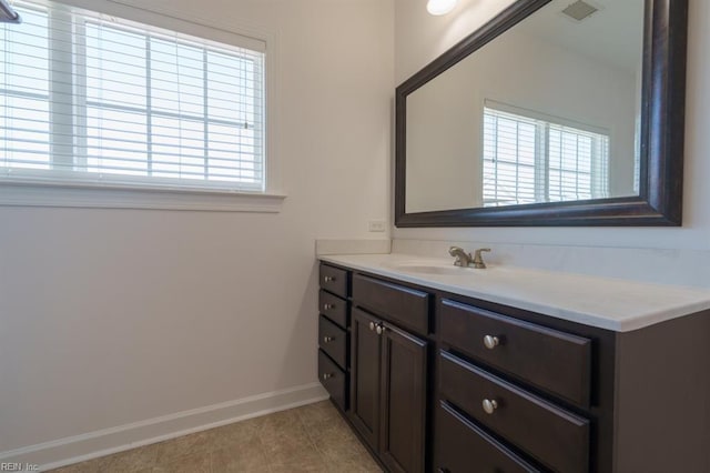 bathroom featuring visible vents, baseboards, vanity, and tile patterned flooring