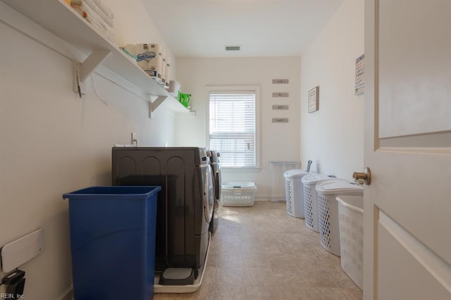 laundry room with laundry area, washing machine and dryer, baseboards, and visible vents