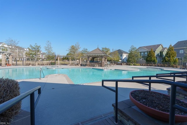 community pool with a gazebo, a residential view, a patio, and fence