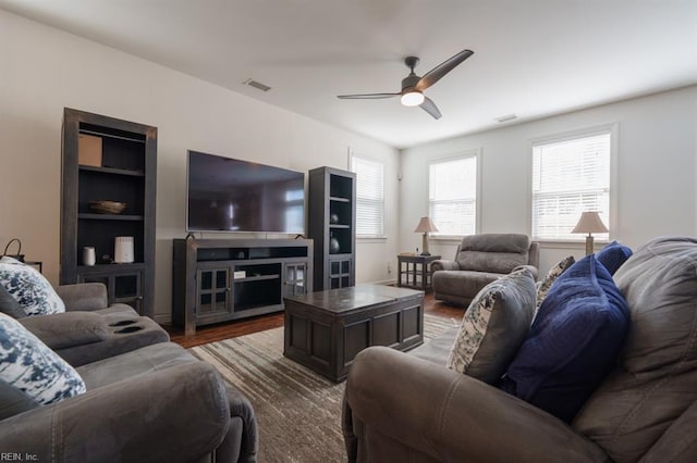 living area featuring visible vents, wood finished floors, and ceiling fan