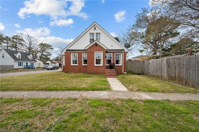 bungalow-style home featuring a front yard, fence, and brick siding