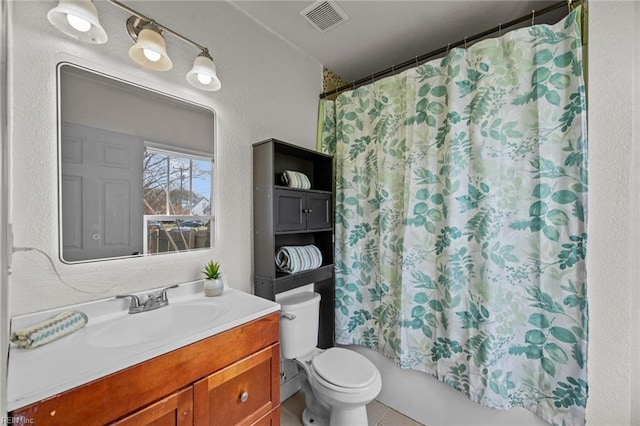 full bathroom with visible vents, toilet, vanity, and a textured wall