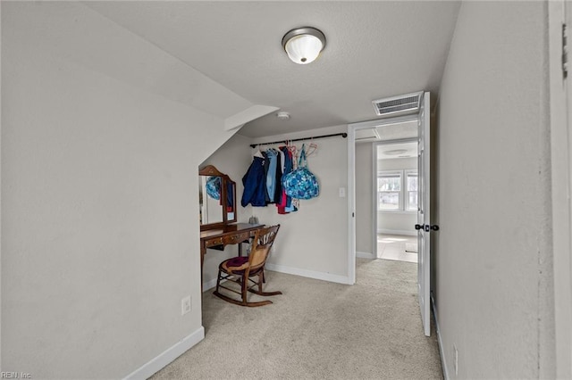 corridor featuring vaulted ceiling, carpet flooring, baseboards, and visible vents