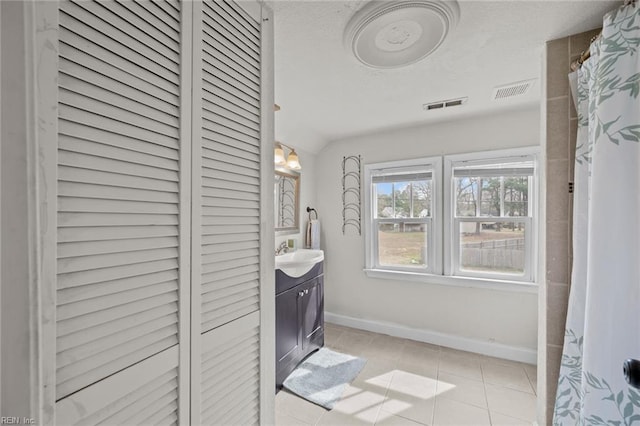 bathroom featuring tile patterned flooring, visible vents, baseboards, vanity, and a textured ceiling