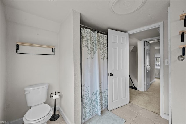 bathroom featuring tile patterned floors, toilet, baseboards, and a shower with curtain