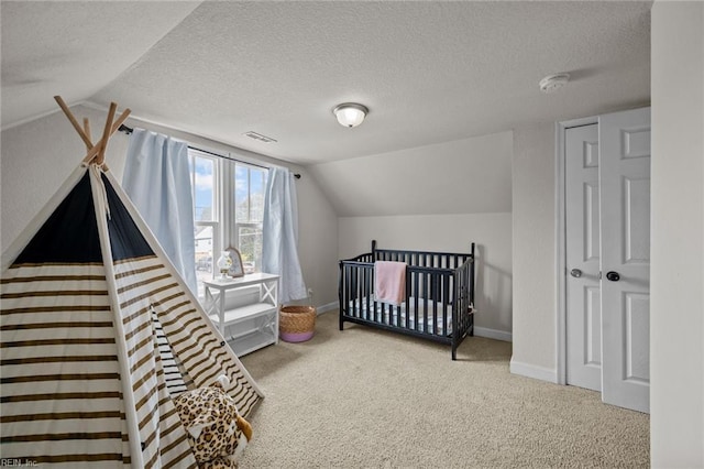 carpeted bedroom featuring a textured ceiling, baseboards, and vaulted ceiling