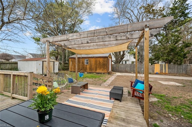 deck featuring a storage shed, a fenced backyard, and an outbuilding