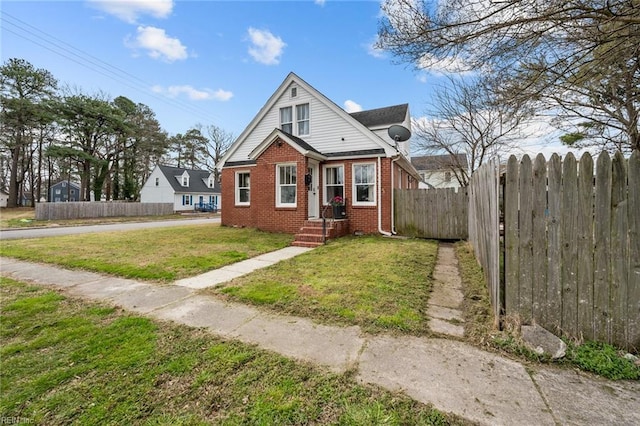 bungalow-style home featuring brick siding, a front lawn, and fence