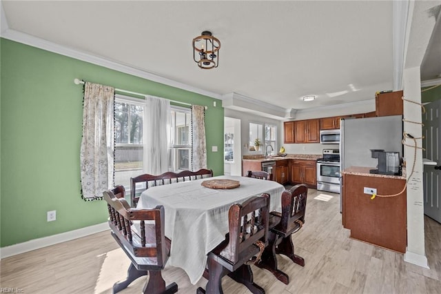 dining area with baseboards, ornamental molding, and light wood finished floors