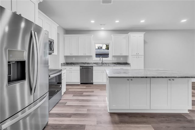 kitchen featuring a kitchen island, recessed lighting, light wood-style floors, appliances with stainless steel finishes, and white cabinets