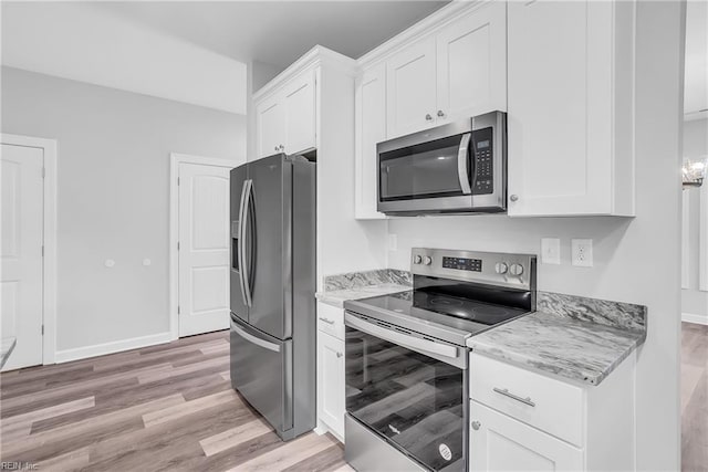 kitchen with light wood-style flooring, appliances with stainless steel finishes, and white cabinetry