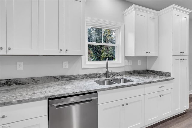 kitchen with dishwasher, white cabinetry, and a sink