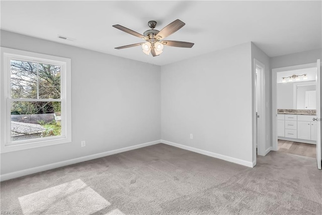 unfurnished bedroom featuring ceiling fan, baseboards, visible vents, and light carpet