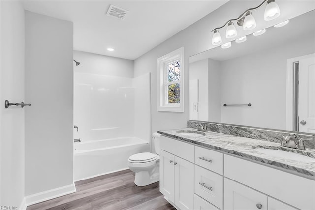 bathroom featuring visible vents, toilet, wood finished floors, and a sink