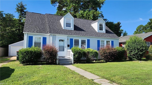 new england style home featuring an outdoor structure, a front lawn, and a shingled roof