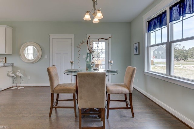 dining room featuring a notable chandelier, baseboards, and dark wood-style flooring