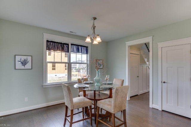 dining space with an inviting chandelier, dark wood-style floors, visible vents, and baseboards