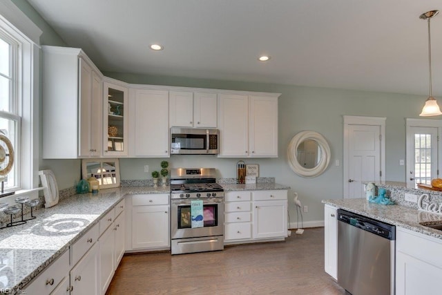 kitchen featuring recessed lighting, appliances with stainless steel finishes, wood finished floors, and white cabinetry