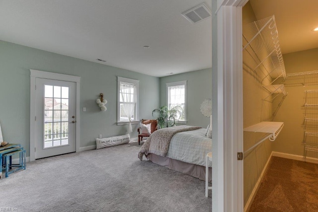 bedroom featuring access to outside, carpet flooring, baseboards, and visible vents