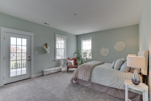 bedroom featuring access to outside, carpet flooring, baseboards, and visible vents