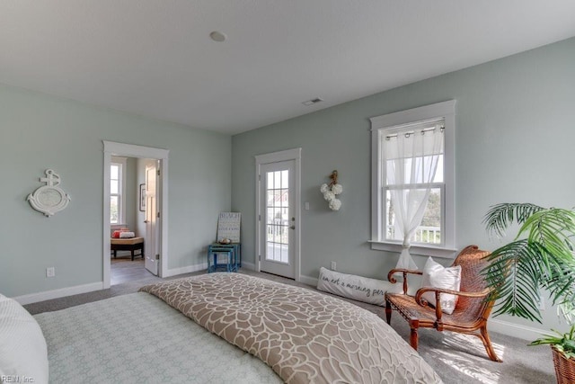 bedroom with baseboards, multiple windows, and carpet