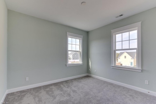 unfurnished room featuring visible vents, baseboards, and carpet