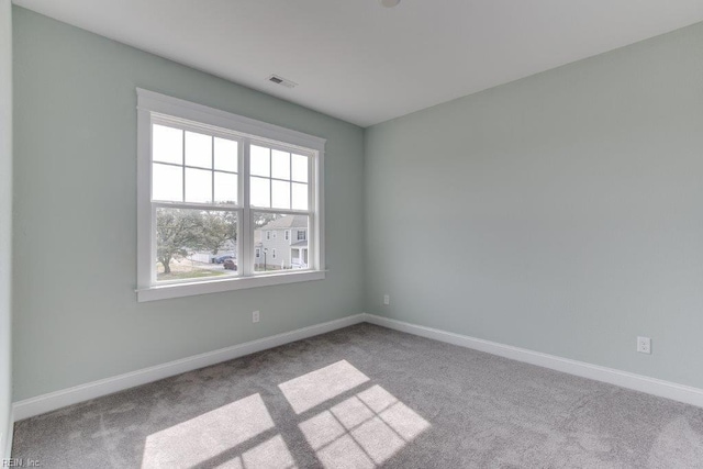 carpeted empty room with visible vents and baseboards