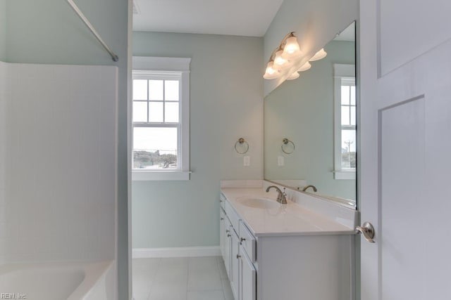 bathroom featuring baseboards, bathing tub / shower combination, vanity, and tile patterned flooring