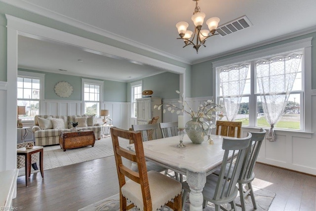 dining room with visible vents, plenty of natural light, crown molding, and light wood-type flooring