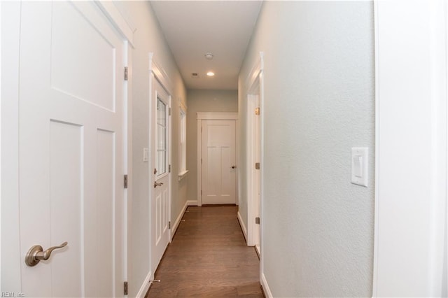 hall with recessed lighting, wood finished floors, baseboards, and a textured wall