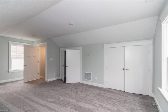 additional living space featuring visible vents, lofted ceiling, baseboards, and carpet flooring