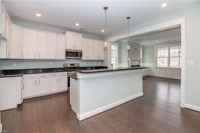 kitchen with dark countertops, white cabinetry, and stainless steel appliances