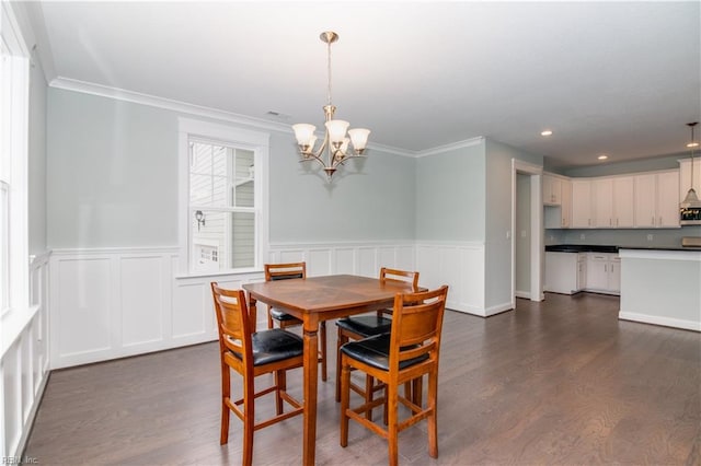 dining space with ornamental molding, recessed lighting, wainscoting, a chandelier, and dark wood-style flooring