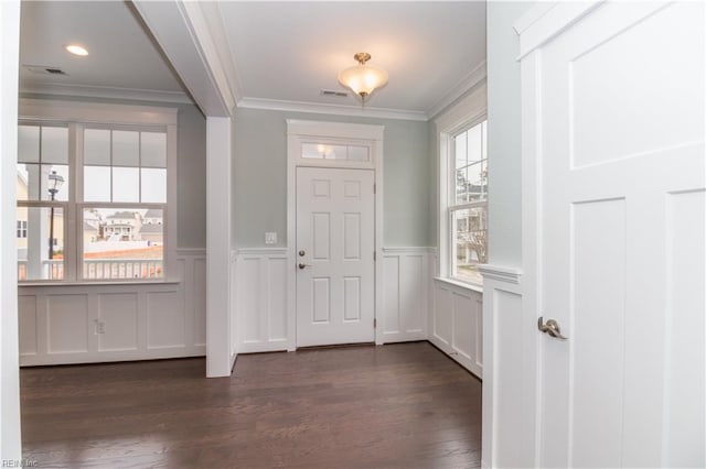 foyer with dark wood-style floors, visible vents, wainscoting, and ornamental molding