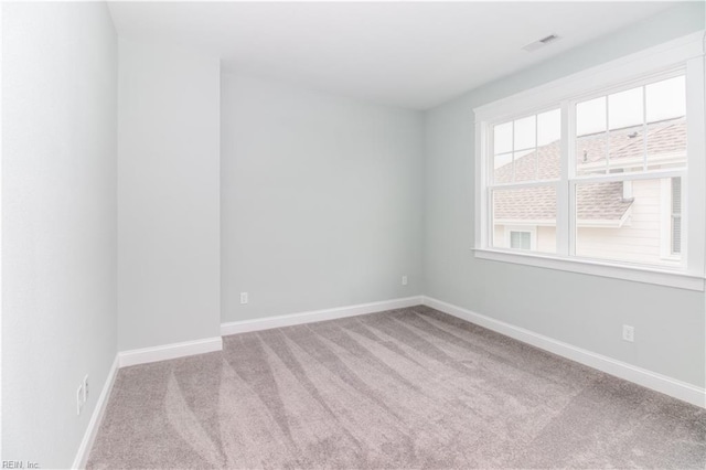 carpeted empty room with baseboards and visible vents