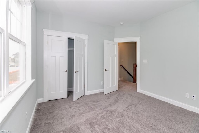 unfurnished bedroom with a closet, baseboards, and carpet floors