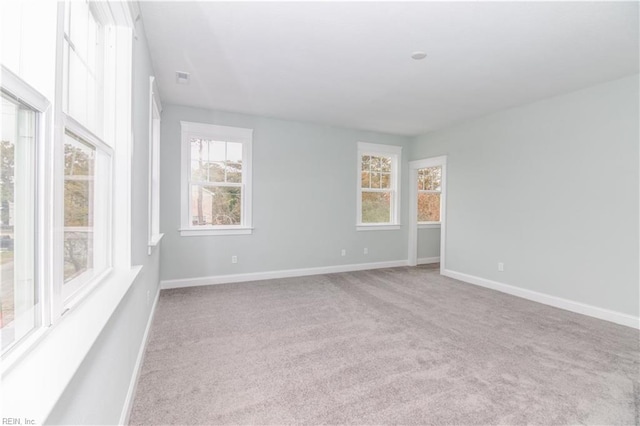 carpeted spare room featuring baseboards