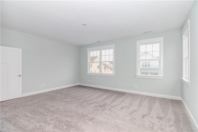 empty room featuring baseboards and carpet floors