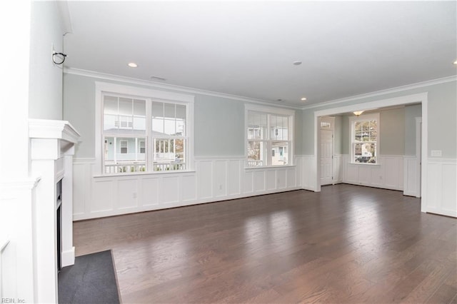 unfurnished living room featuring a wainscoted wall, a fireplace with flush hearth, recessed lighting, dark wood-style flooring, and crown molding