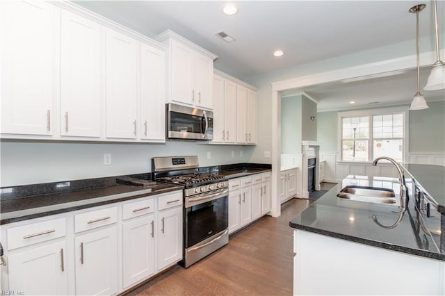 kitchen featuring a sink, stainless steel appliances, visible vents, and white cabinets