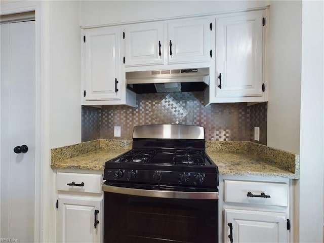 kitchen with under cabinet range hood, white cabinets, gas stove, and tasteful backsplash